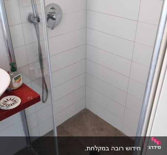 מקלחת עם ראש מקלחת ודלת זכוכית